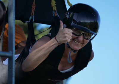 Chica con el pulgar levantado, lista para saltar en la tirolina.