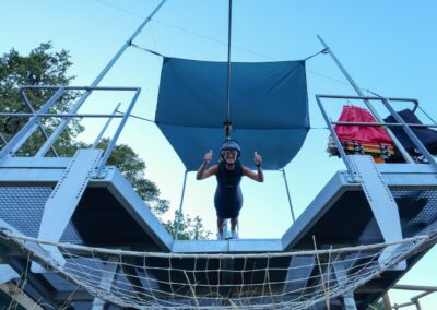 Chica saltando en tirolina en el momento inicial del vuelo.